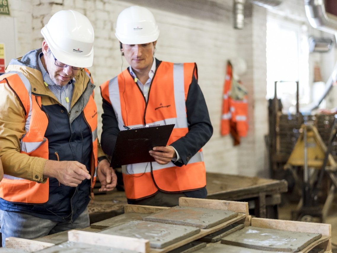 Plant managers inspecting hand made clay roof tiles